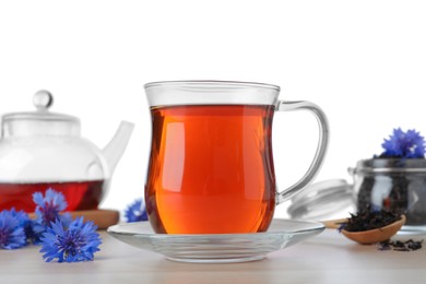 Photo of Cornflower tea and fresh flowers on wooden table