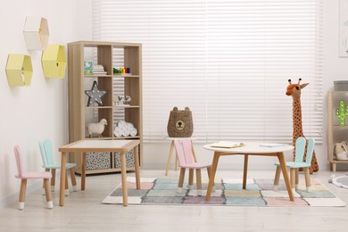 Photo of Child`s playroom with different toys and modern furniture. Stylish kindergarten interior