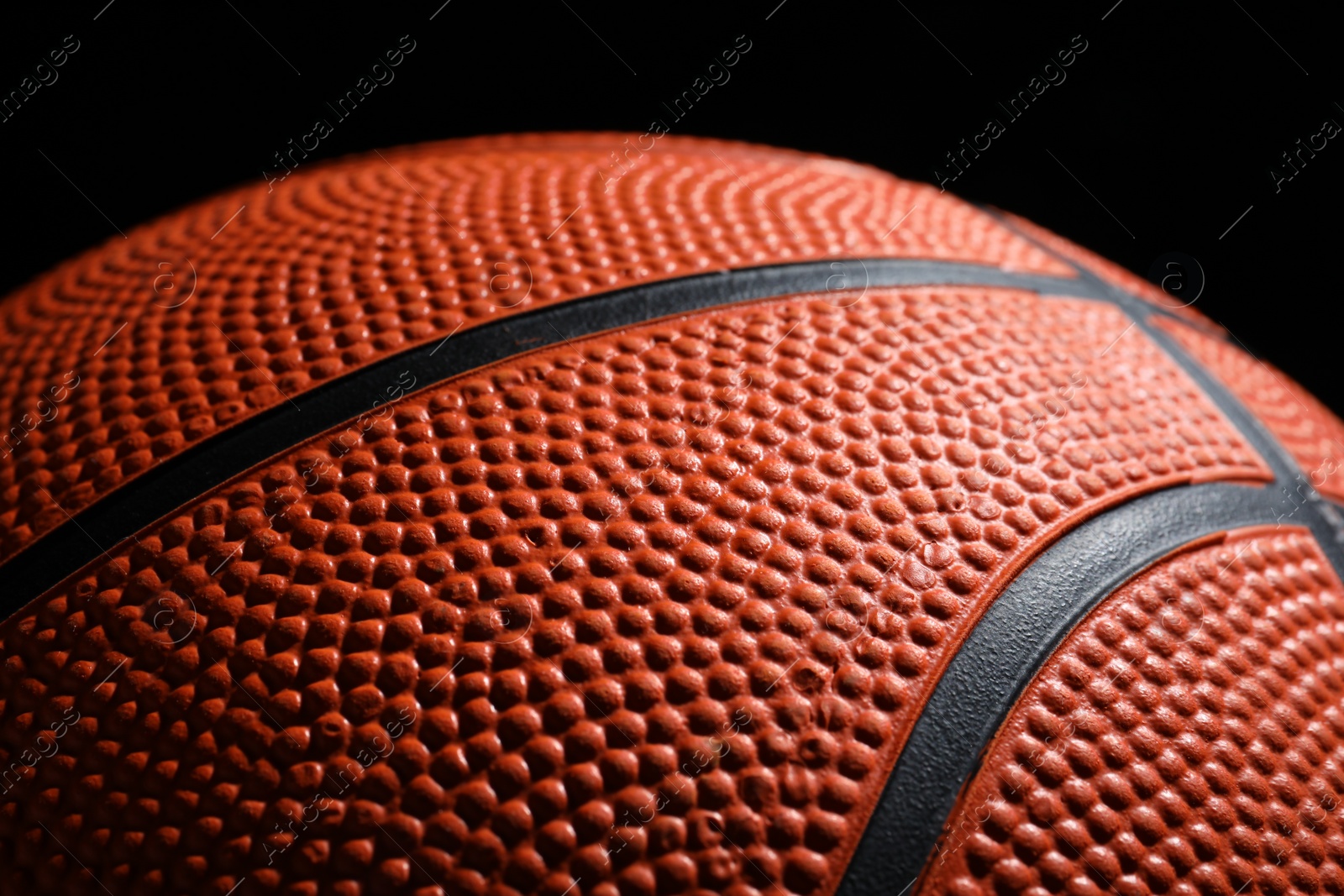 Photo of Orange basketball ball on black background, closeup