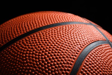 Orange basketball ball on black background, closeup