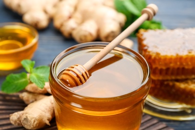 Photo of Jar of honey and other natural cold remedies on table, closeup