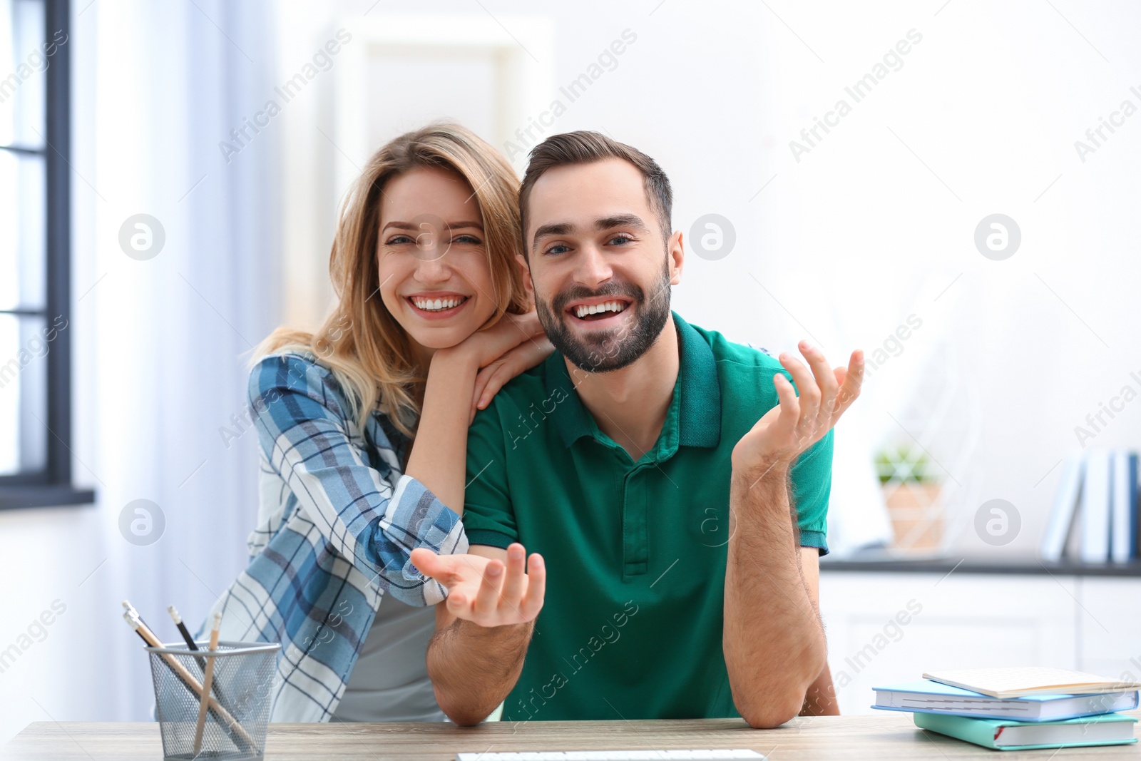 Photo of Happy couple using video chat for conversation indoors