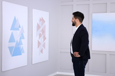 Young man at exhibition in art gallery