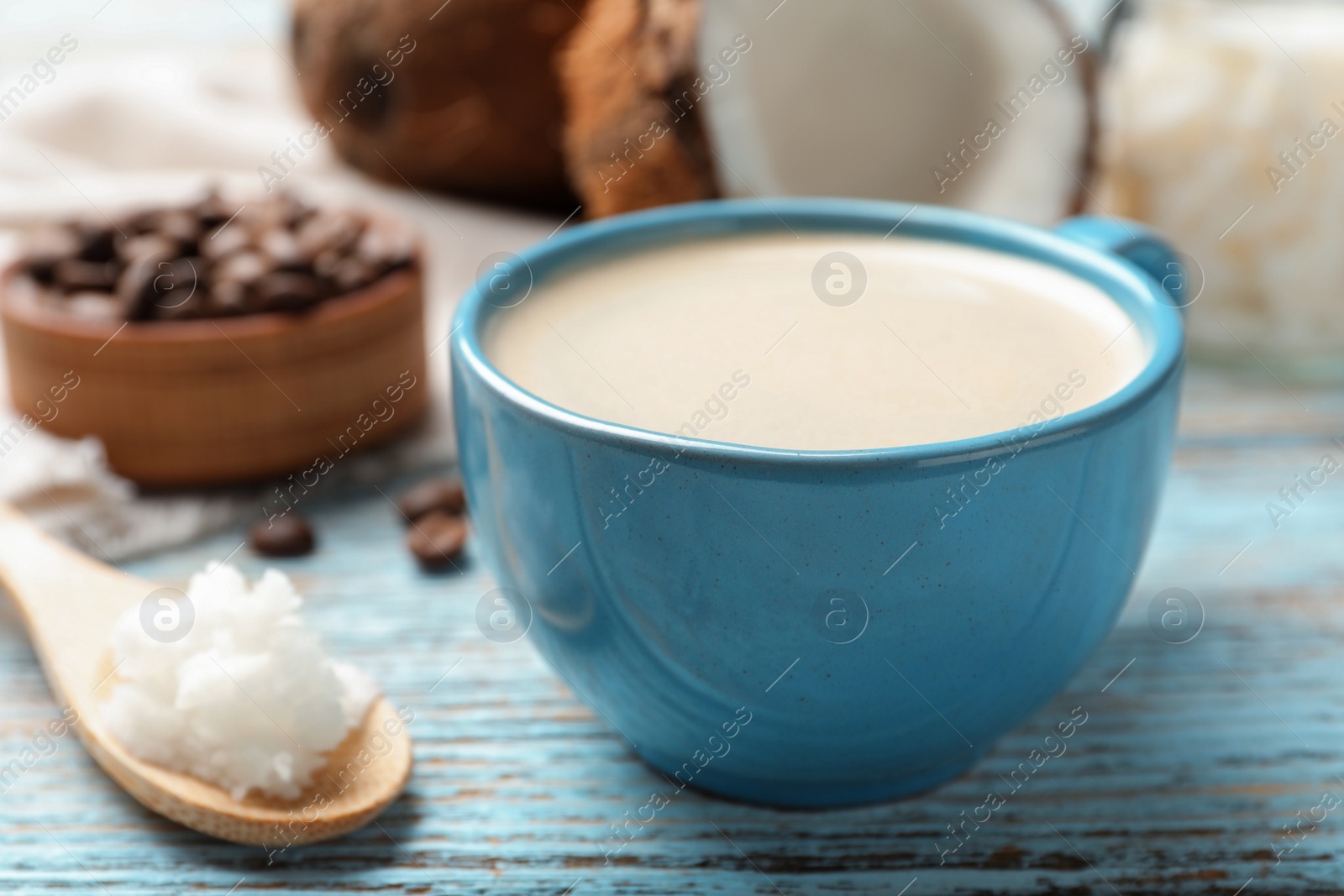 Photo of Delicious coffee with organic coconut oil on wooden table