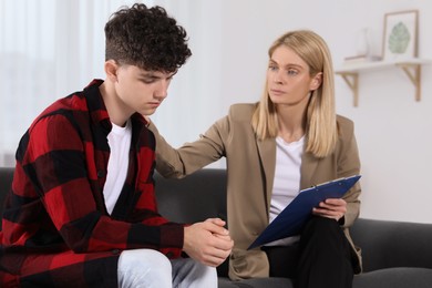 Photo of Psychologist working with teenage boy in office. Teenager problems