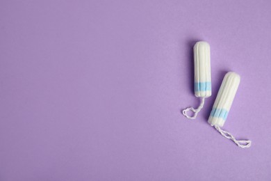 Tampons on lilac background, flat lay. Space for text