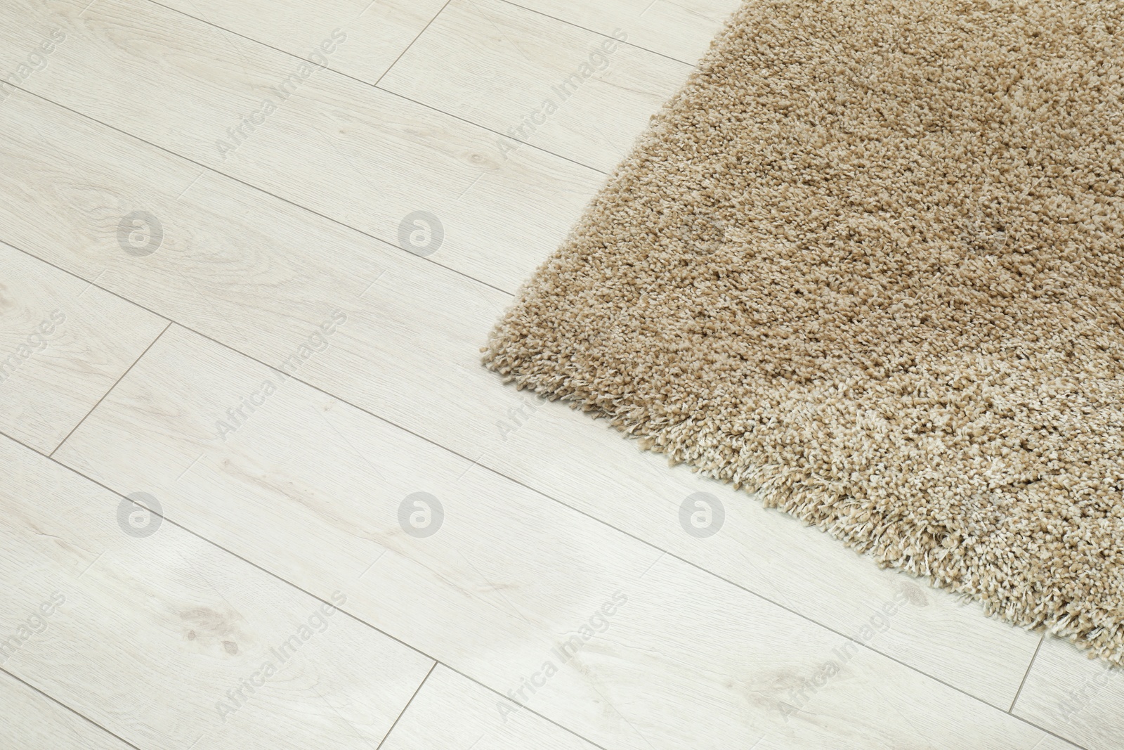 Photo of Soft beige carpet on white laminated floor indoors, space for text