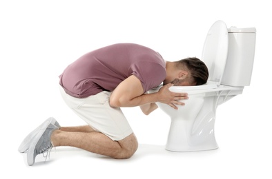 Photo of Young man vomiting in toilet bowl on white background