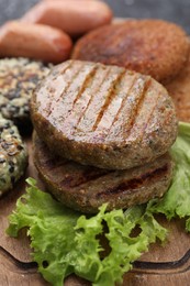 Photo of Different tasty vegan meat products on wooden board, closeup
