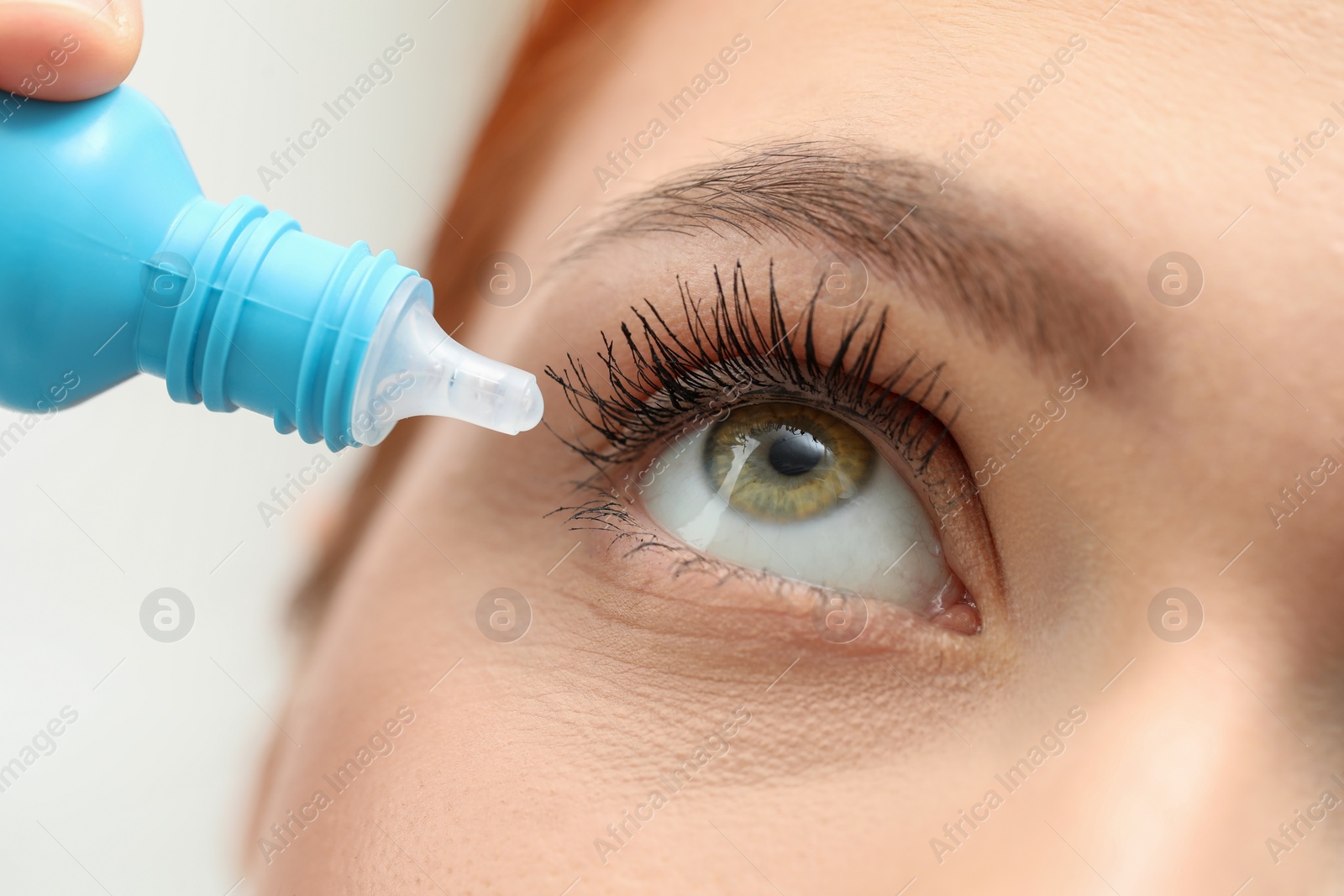 Photo of Woman applying medical eye drops, macro view