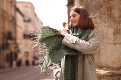 Photo of Beautiful woman in warm scarf on city street