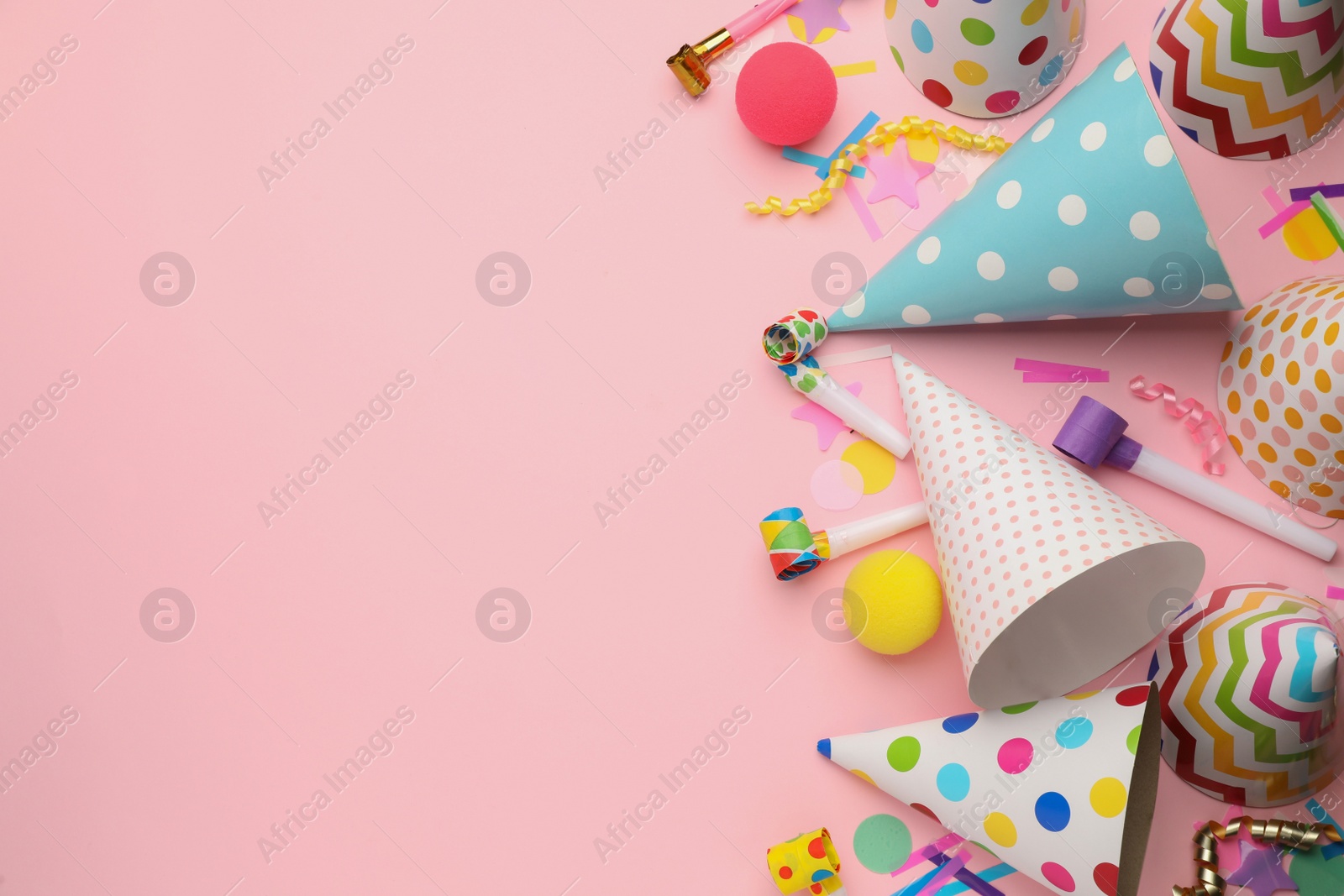 Photo of Flat lay composition with party hats and other festive items on pink background. Space for text