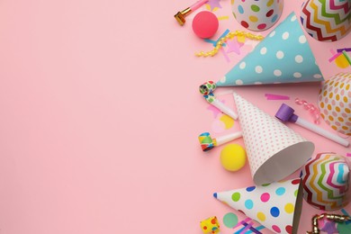 Photo of Flat lay composition with party hats and other festive items on pink background. Space for text