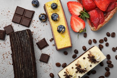 Photo of Flat lay composition with different tasty cakes on light grey table