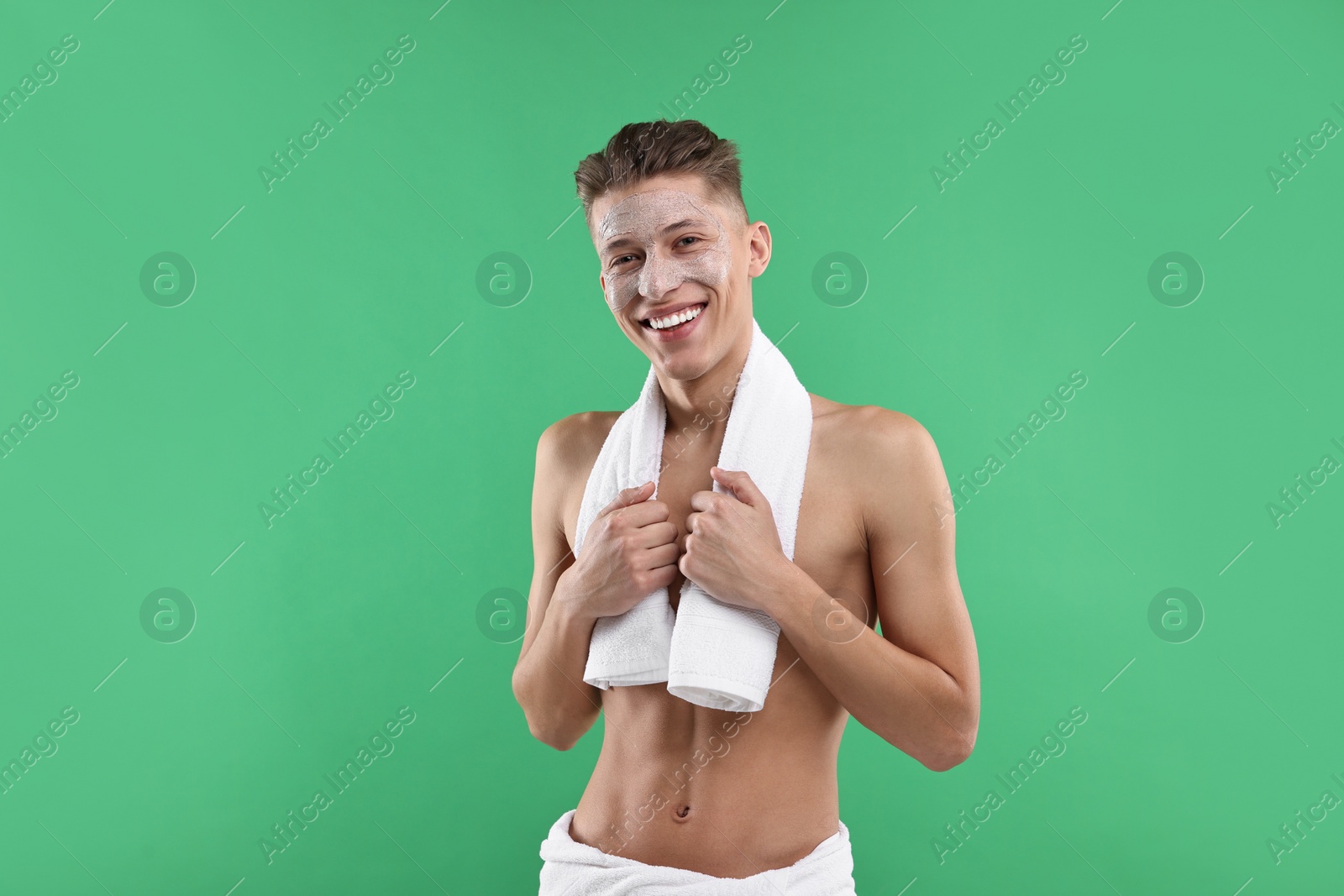 Photo of Handsome man with facial mask on his face against green background