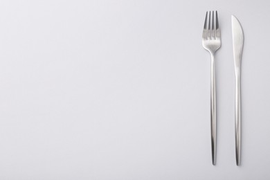 Stylish cutlery on grey table, top view. Space for text