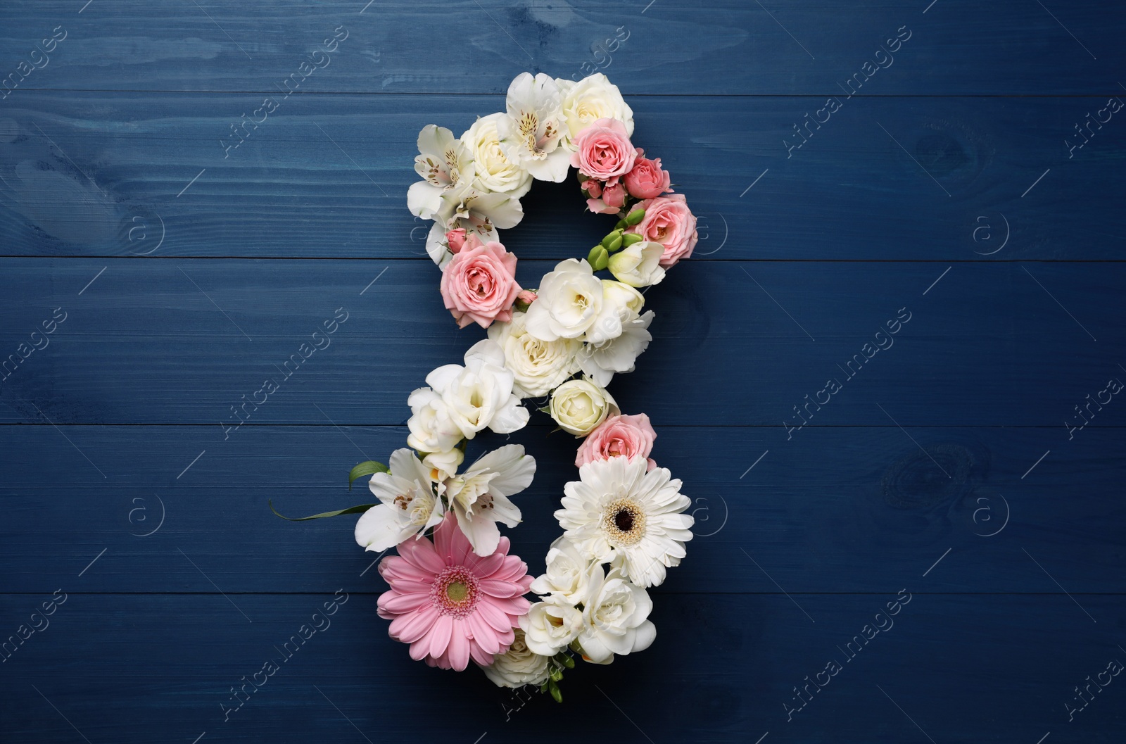 Photo of Number 8 made of beautiful flowers on blue wooden table, flat lay. International Women's day