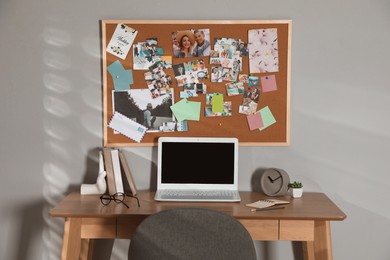 Photo of Stylish workplace with vision board and laptop