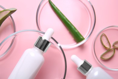 Photo of Flat lay composition with aloe vera leaves and cosmetic products on pink background