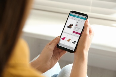 Image of Woman shopping online via smartphone indoors, closeup