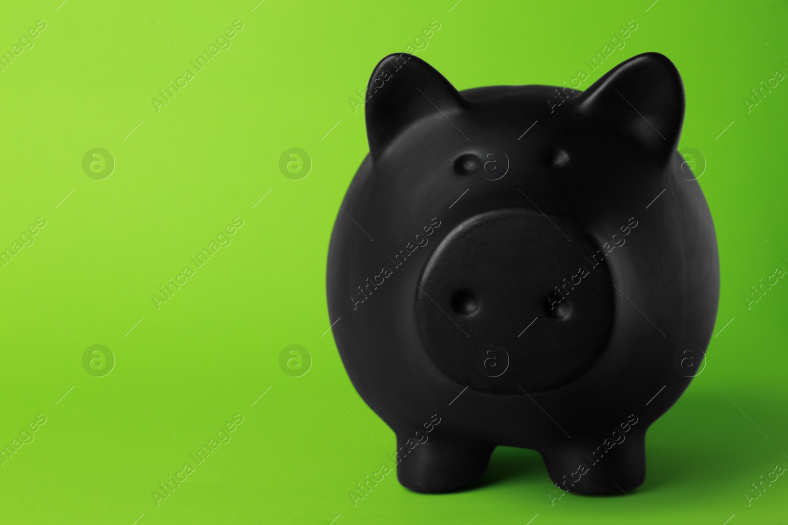 Photo of Ceramic piggy bank on green background. Space for text