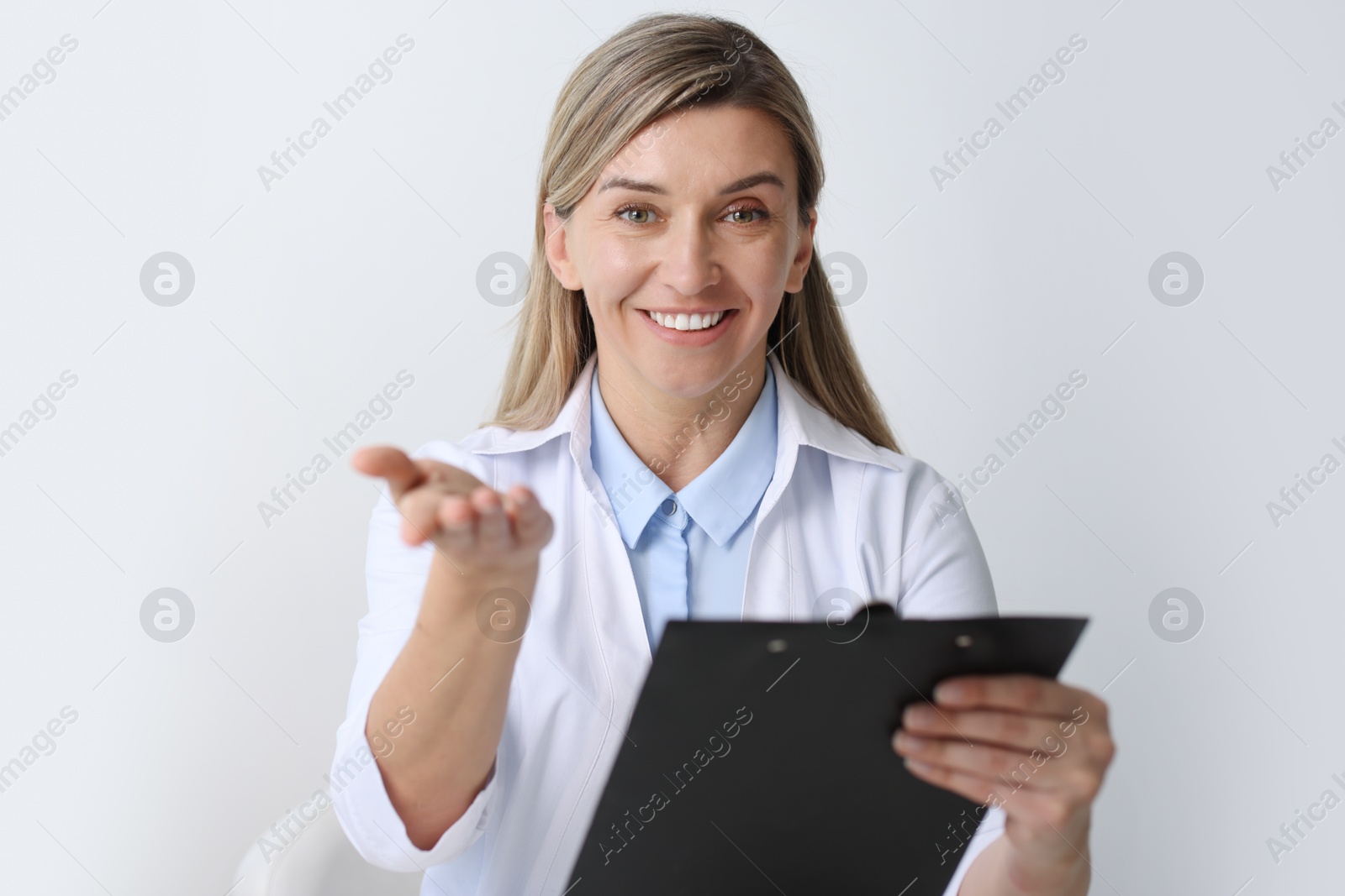 Photo of Portrait of happy doctor with clipboard in hospital