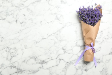 Photo of Beautiful lavender bouquet on white marble background, top view. Space for text