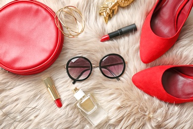 Flat lay composition with cosmetics and stylish accessories on fur