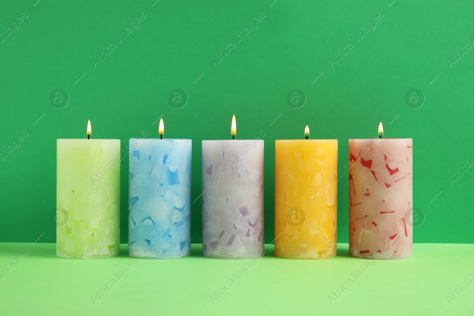 Photo of Alight scented wax candles on color background