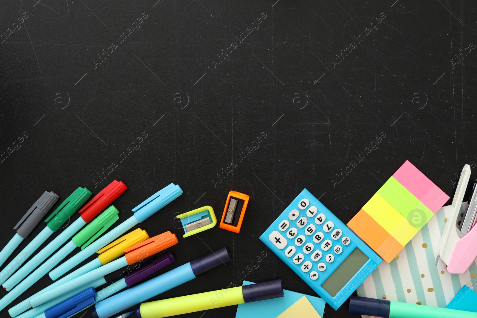 Photo of Different stationery on blackboard, flat lay with space for text. Back to school