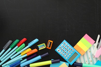 Different stationery on blackboard, flat lay with space for text. Back to school