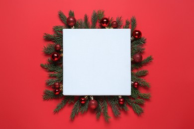 Photo of Blank canvas and Christmas decor on red background, flat lay. Space for design