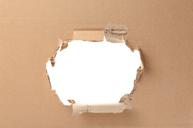 Photo of Hole in cardboard on white background. Recyclable material