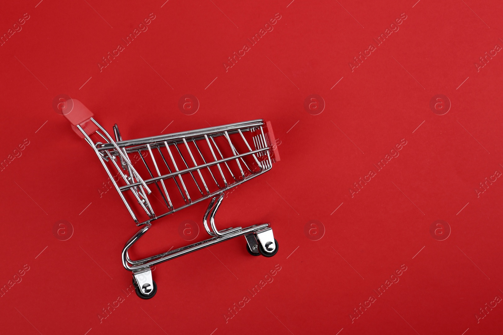 Photo of Empty shopping trolley on color background, top view. Space for text