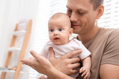 Happy father with his little baby at home