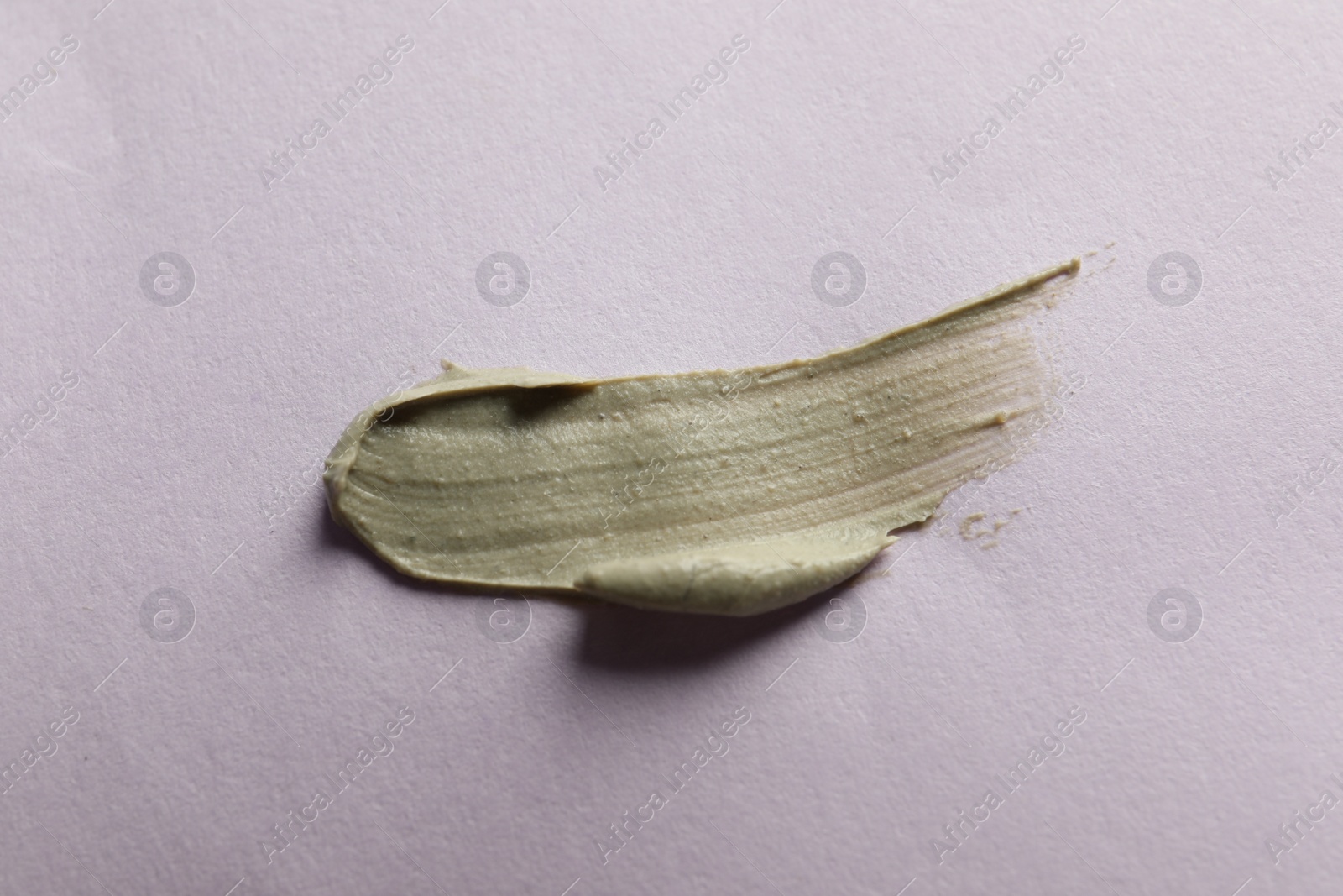 Photo of Sample of face cream on lilac background, top view