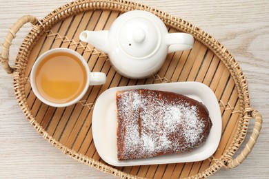 Delicious yeast dough cake and tea on wooden table, top view