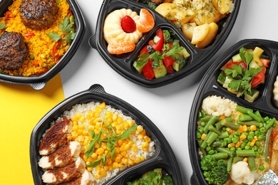 Photo of Lunchboxes with different meals on color table, flat lay. Healthy food delivery