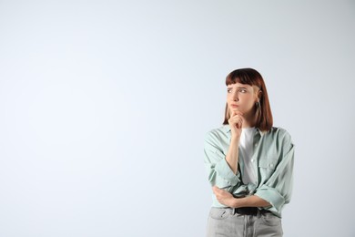 Photo of Portrait of confused young girl on white background. Space for text