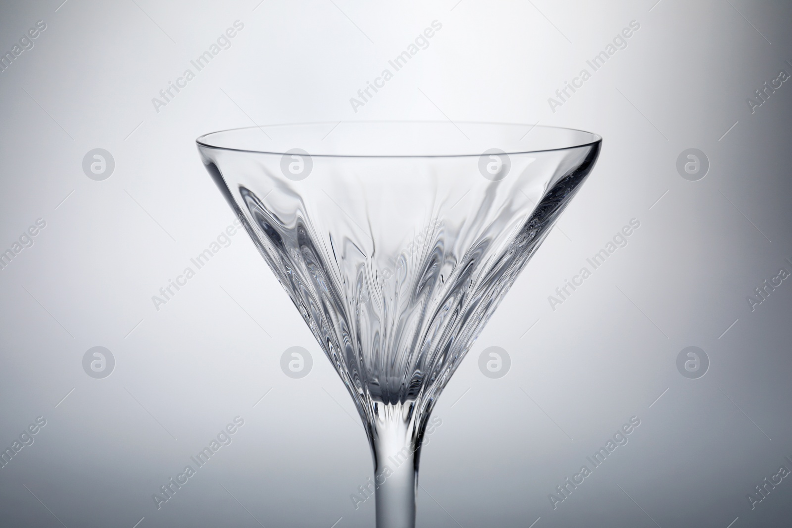 Photo of Elegant empty martini glass on grey background, closeup