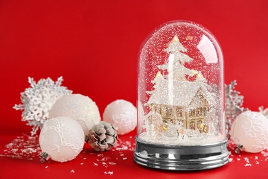 Beautiful Christmas snow globe and festive decor on red background