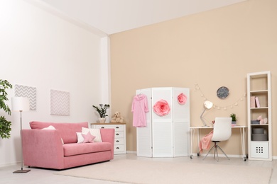 Photo of Cozy child room interior with sofa, study station and modern decor elements