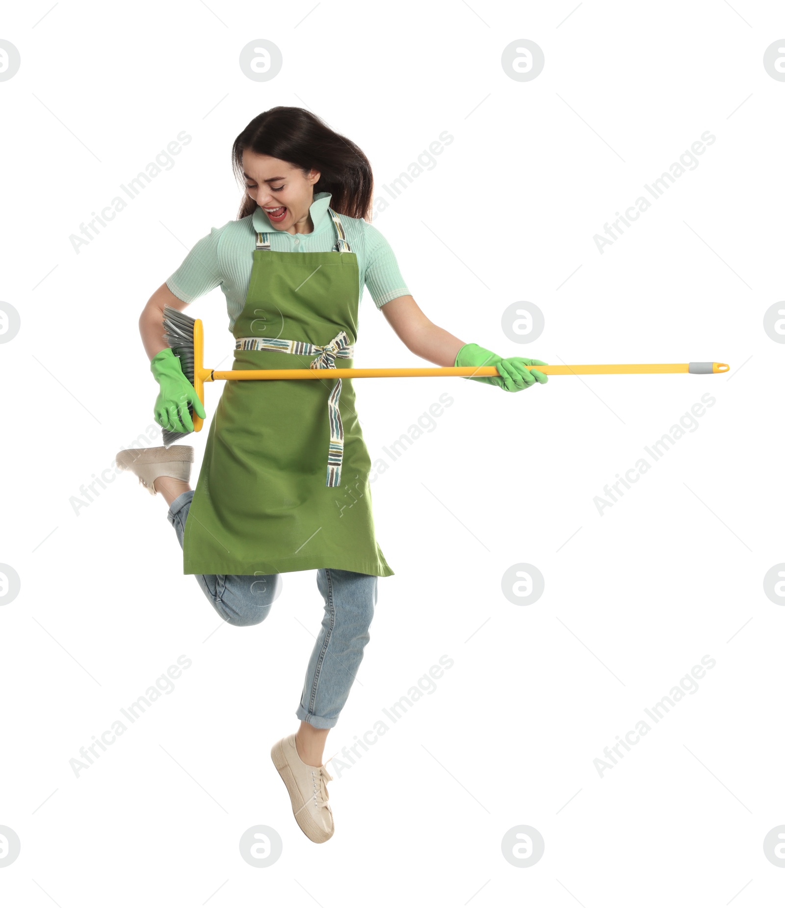 Photo of Beautiful young woman with broom jumping on white background