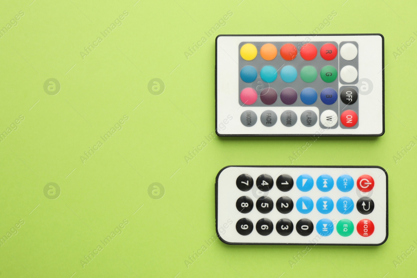 Photo of Remote controls on light green background, flat lay. Space for text