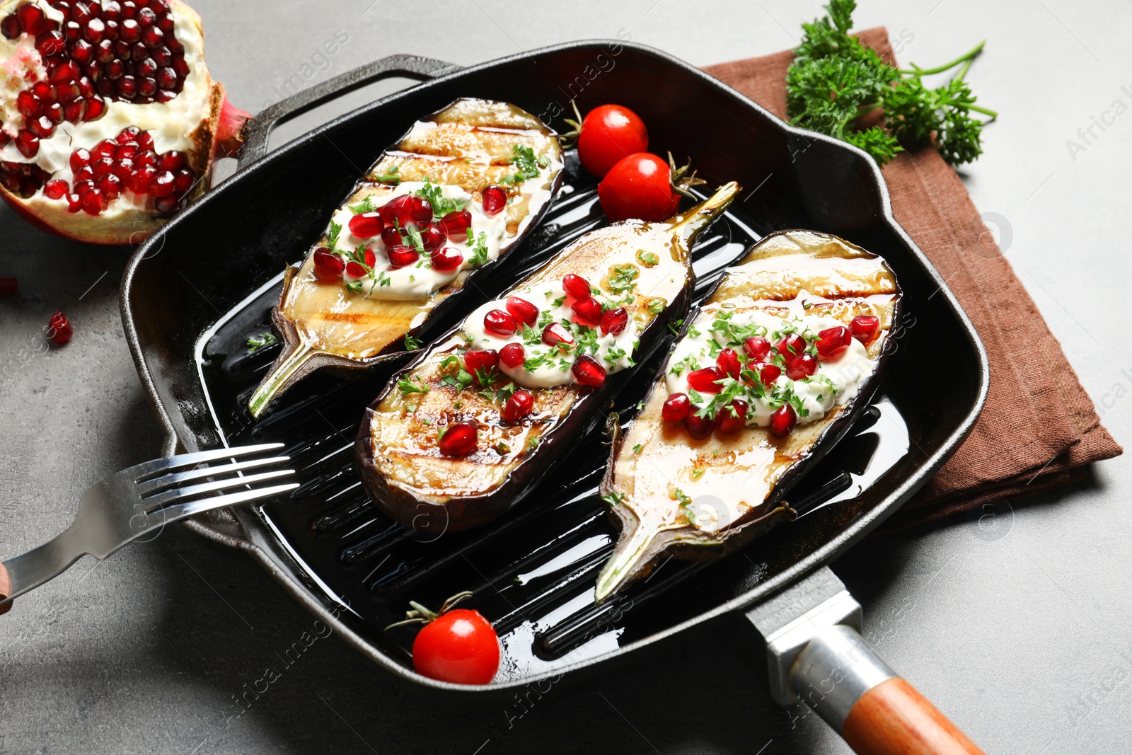 Photo of Grill pan with fried eggplants on table