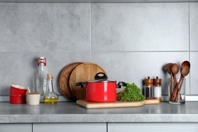 Photo of Set of different cooking utensils and products on grey countertop in kitchen