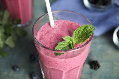 Photo of Tasty fresh milk shake with mint on table, closeup
