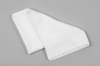 Photo of Folded white beach towel on light grey background, top view