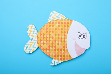 Photo of Funny paper fish on light blue background, top view. April Fool's Day