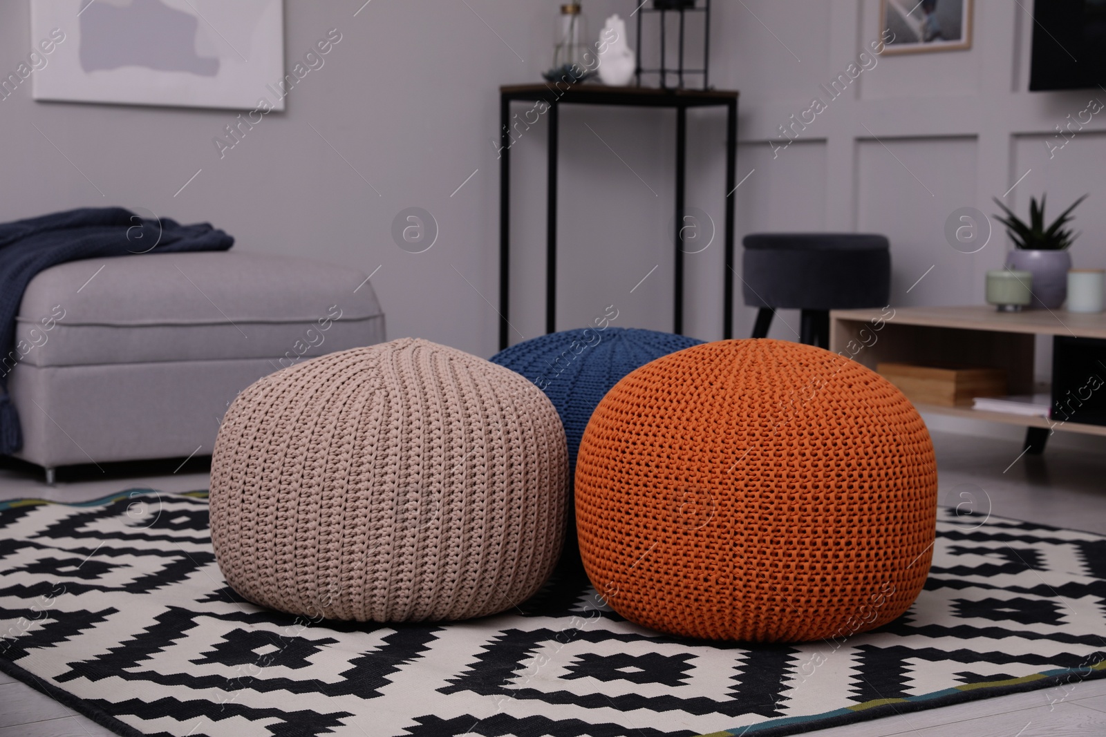 Photo of Different stylish poufs on floor in living room